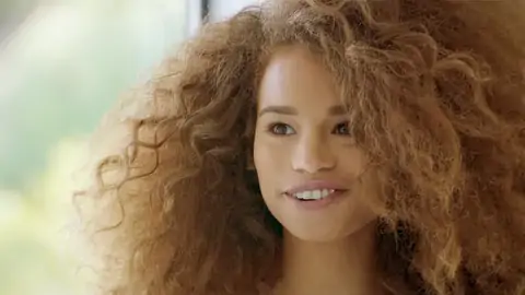 Teenager dark-hued with wavy hair is railing a huge spear on the sofa