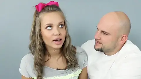 Platinum-Ash-blonde nubile with smallish bosoms talking to a clean-shaven man